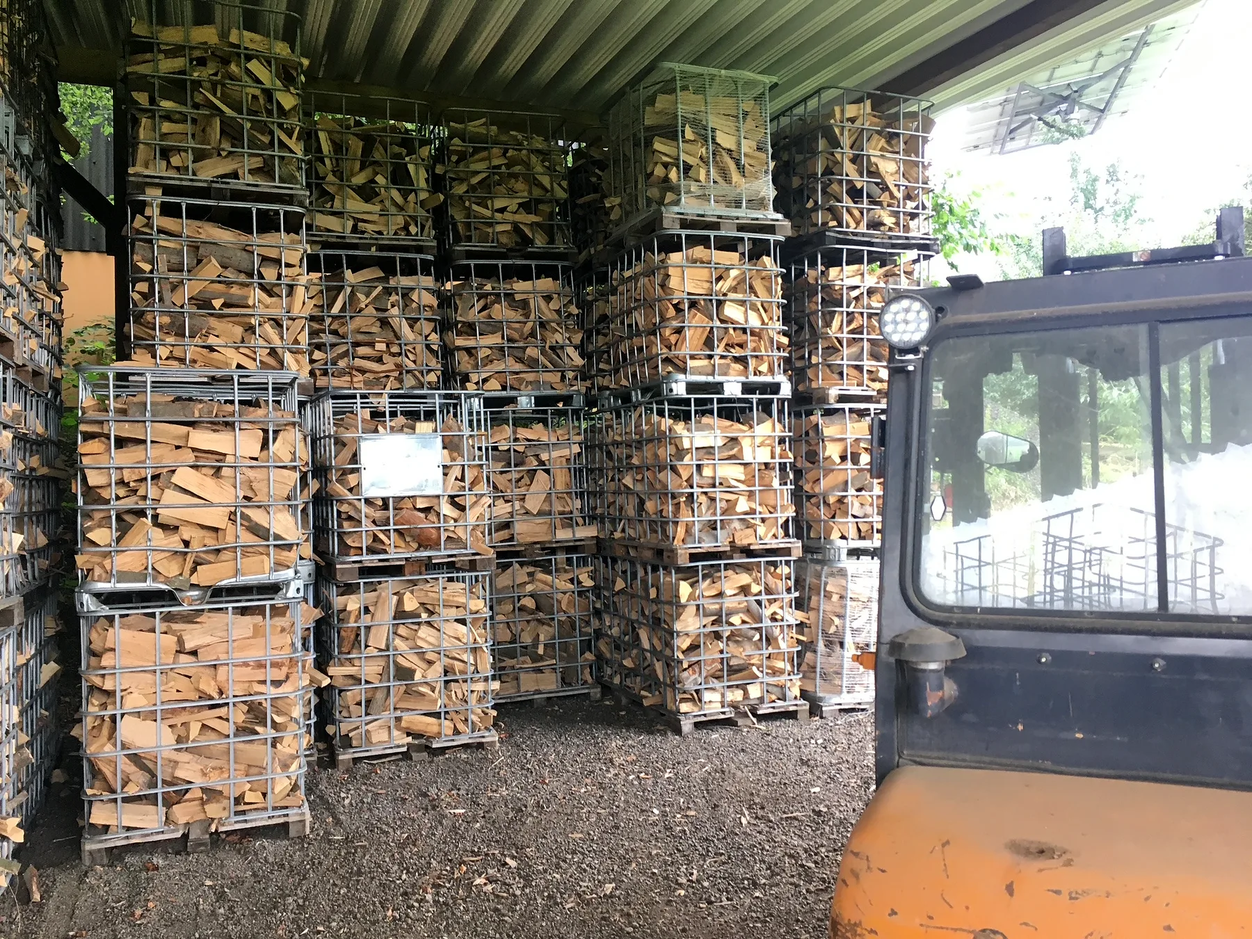 Brennholz in Gitterboxen unter Dach